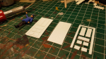 Started with the doors. The piece to the left is the result of the two to the right put together. Figure right is 1/32 for compare, again ...

This is a perfect example what the curio cutter is good for. Drawing took some time but now I can cut out as m