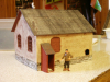 Pict8735 -- Rogers Workshop for 1/35. The walls are sandpaper glued to a shoebox and the roof is made with an old copy machine and part of the roof from a 0-scale building kit.